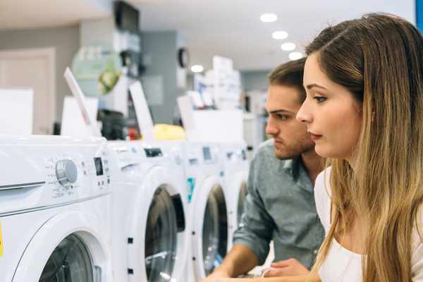 A couple inspecting a front load washer